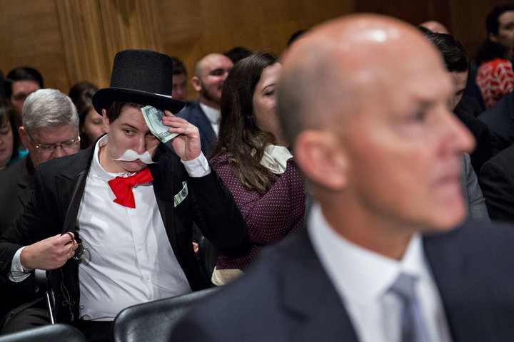 Amanda Werner of Americans for Financial Reform and Public Citizen sits in costume behind Richard Smith, former chairman and chief executive officer of Equifax Inc., right, before a Senate Banking Committee hearing in Washington, D.C., U.S., on Wednesday, Oct. 4, 2017. Lawmakers grilled Smith on Tuesday after hackers attacked the company's systems and got access to sensitive information for 145.5 million Americans. Photographer