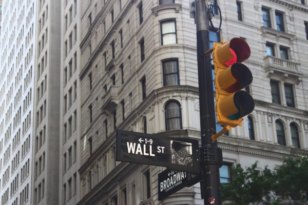 Wall Street sign and a stoplight turned red - Photo by Roberto Júnior on Unsplash
