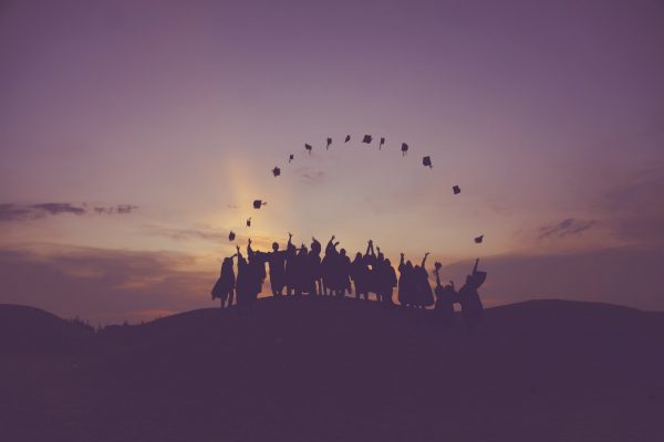 student graduates thowing their caps into the air