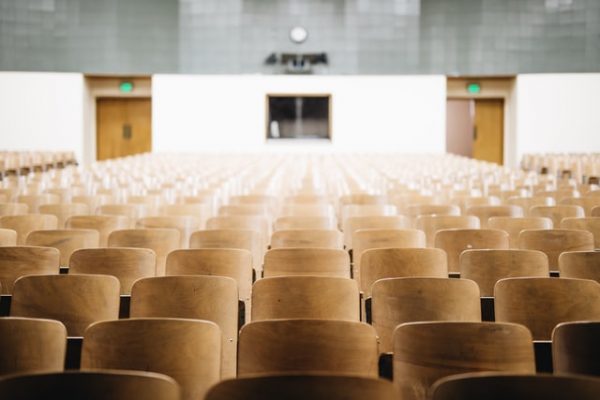 Empty chairs in a college auditorium - Photo by Nathan Dumlao on Unsplash